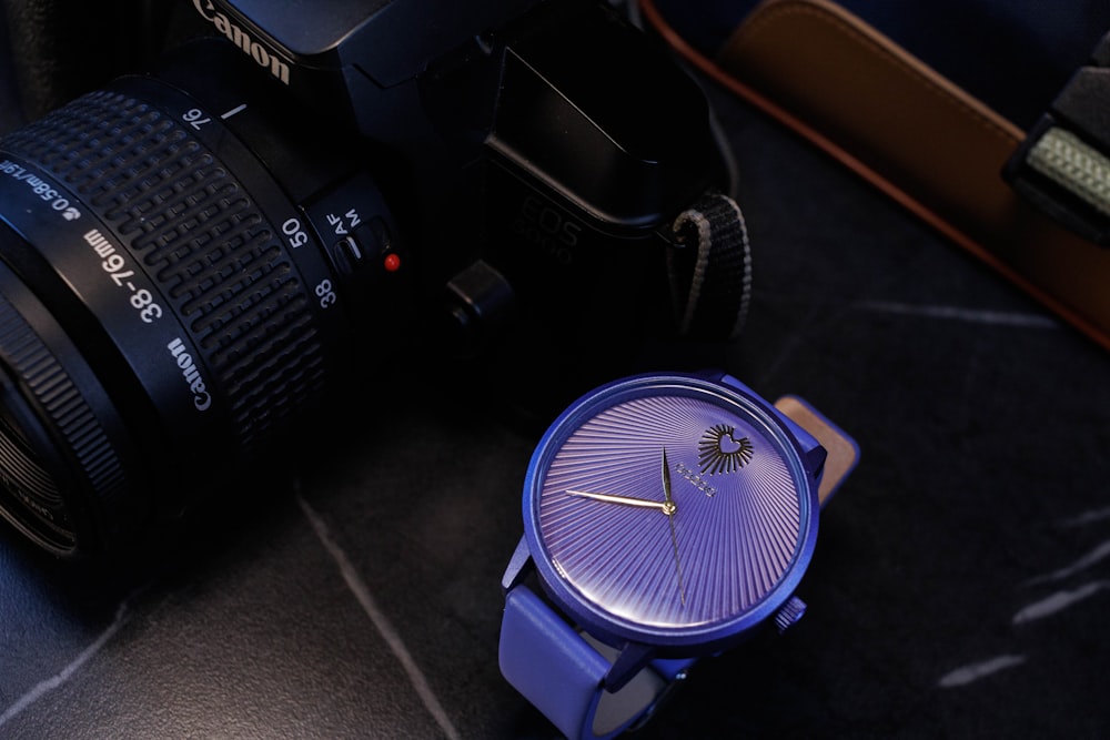 a camera and a watch on a table