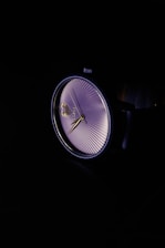 Close-up of a sleek wristwatch dial with gold accents against a matte black background.