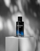 a bottle of cologne sitting on top of a white block