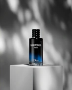 a bottle of cologne sitting on top of a white block