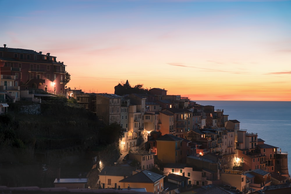 a city by the ocean at night with lights on