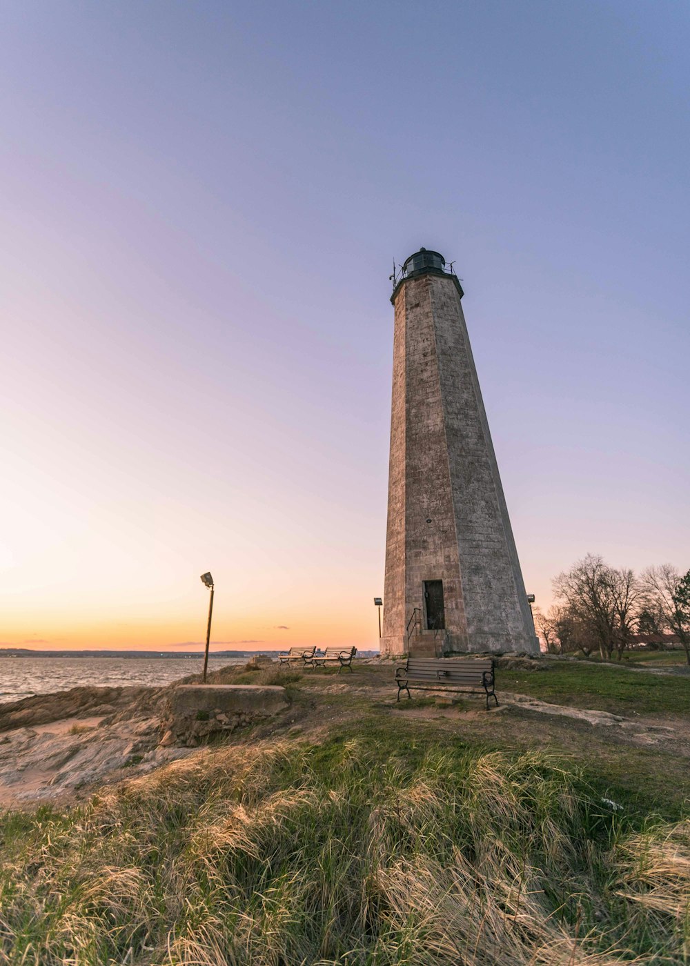 a tall light house sitting on top of a lush green field