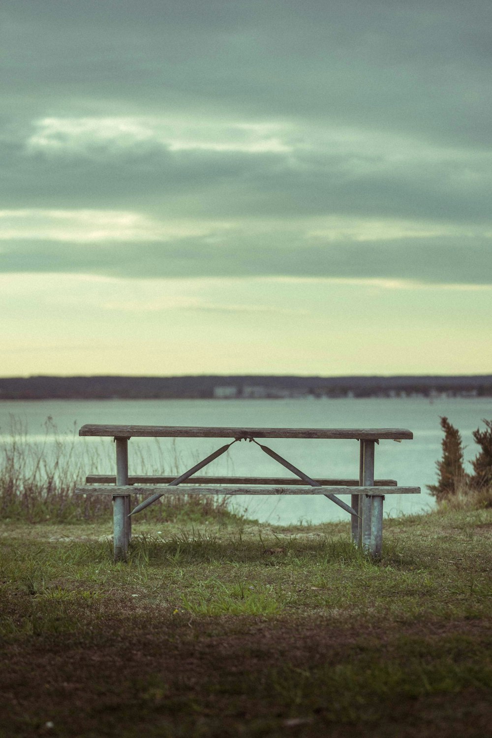 a wooden bench sitting on top of a lush green field