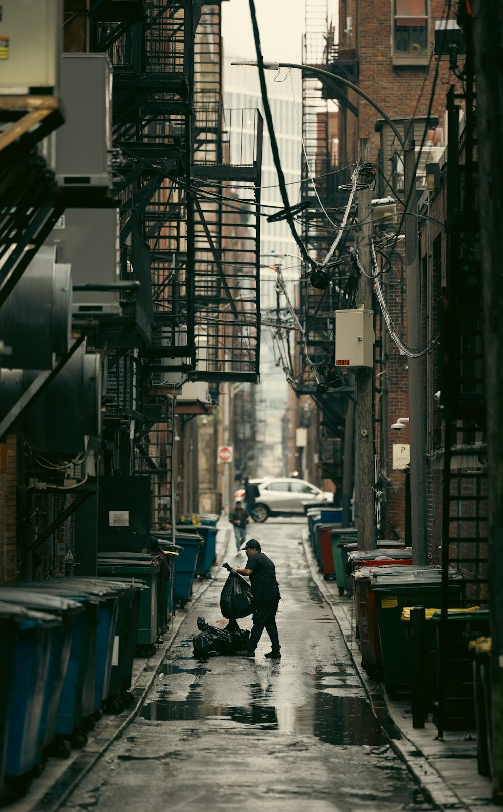 a person kneeling down in the middle of a street