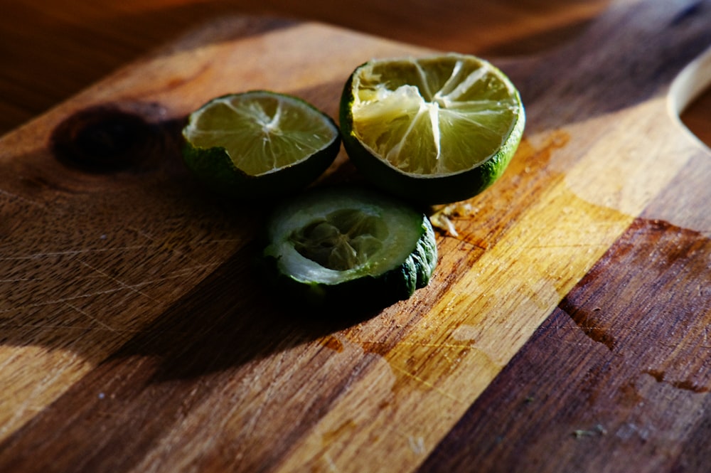 a wooden cutting board topped with sliced up limes