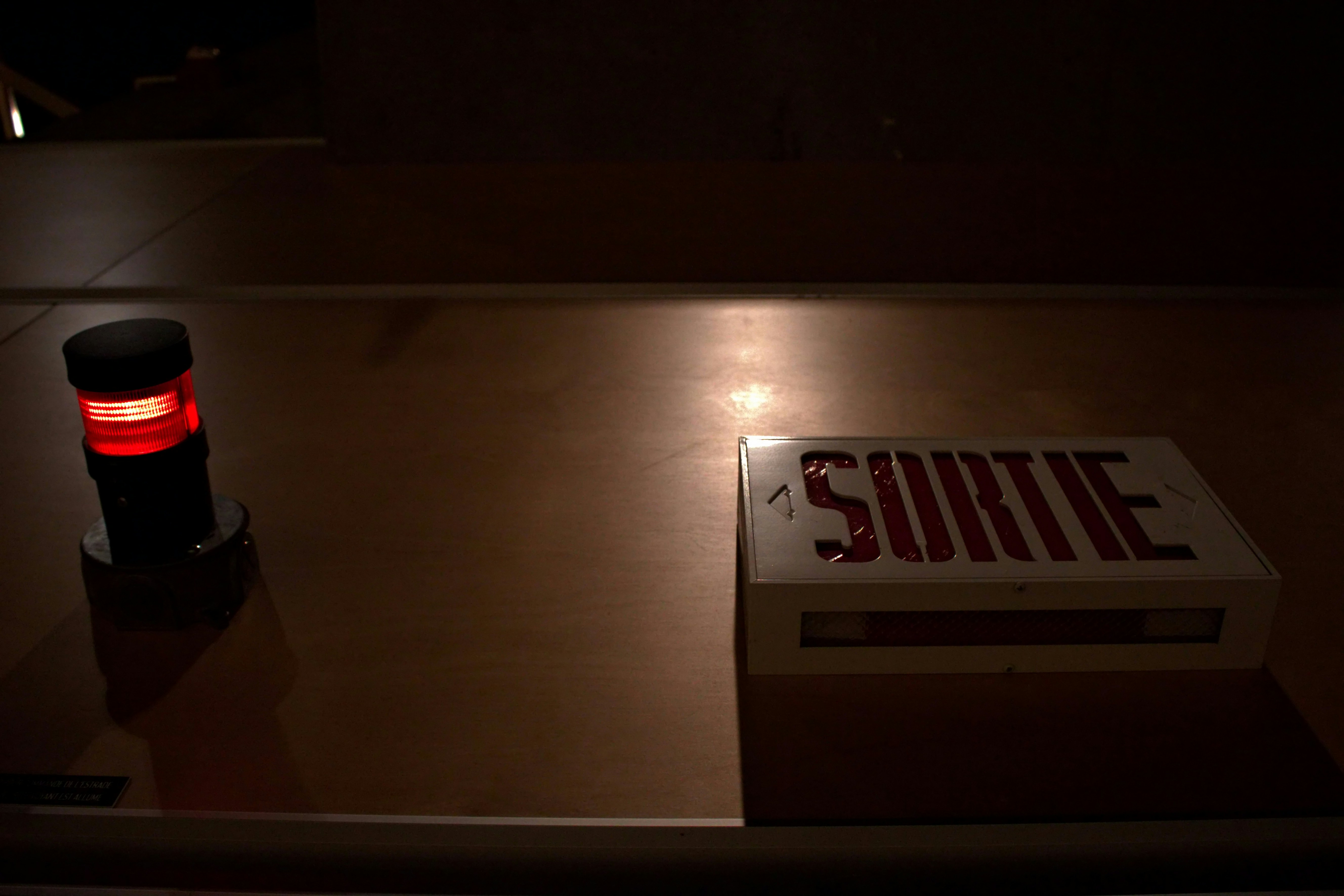 a red light sitting on top of a table next to a sign