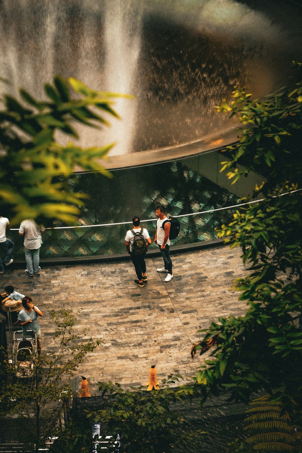 a group of people standing around a waterfall