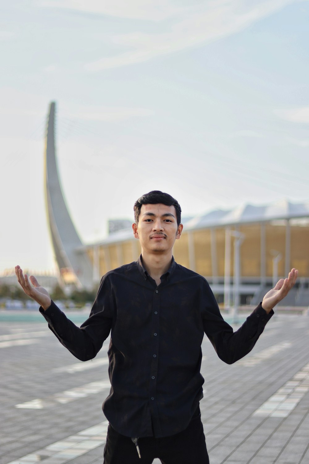 a man standing in front of a building with his hands in the air