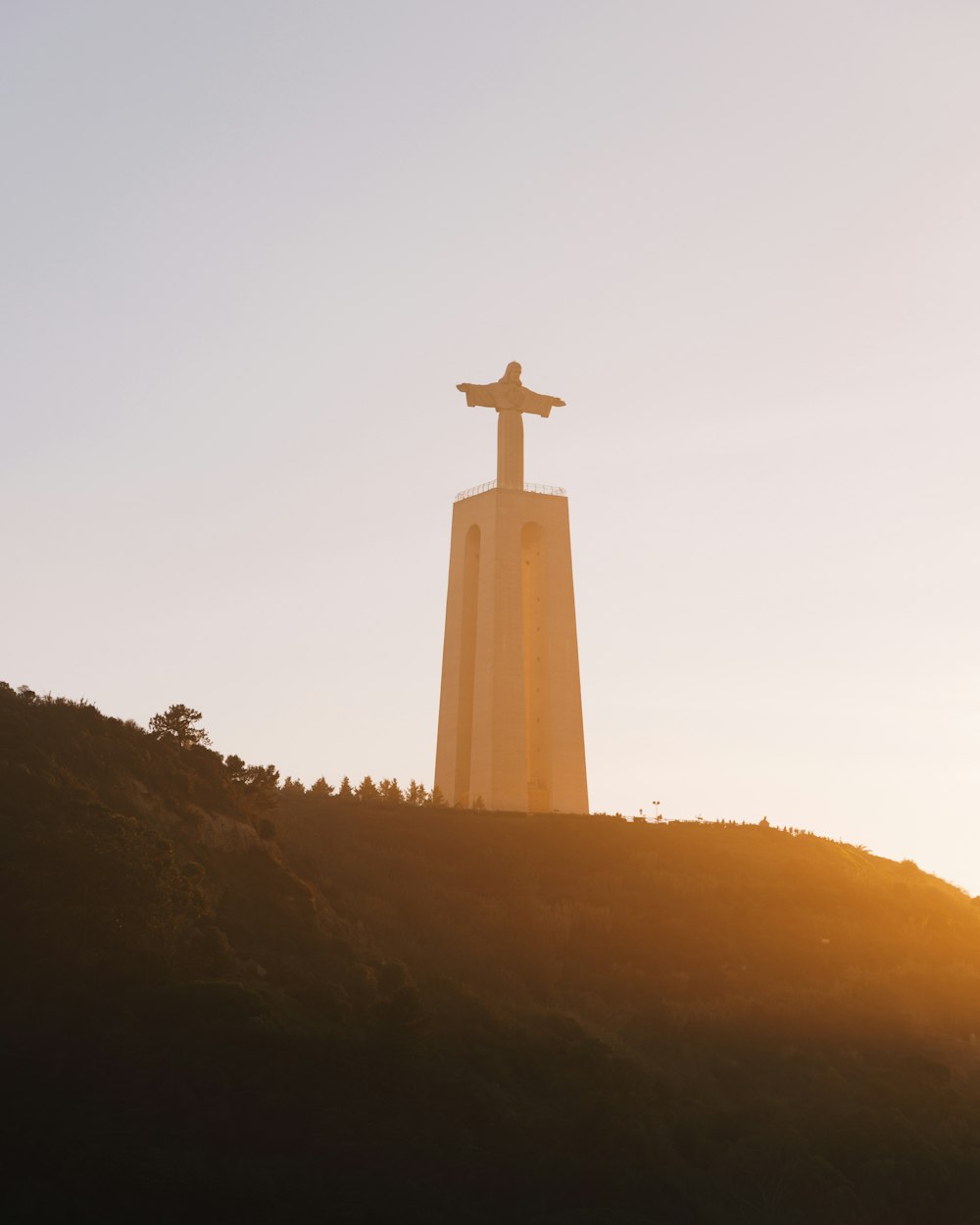 a cross on top of a hill with a sky background