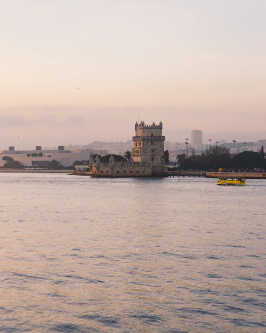 The iconic Belém Tower standing proudly by the Tagus River at sunset