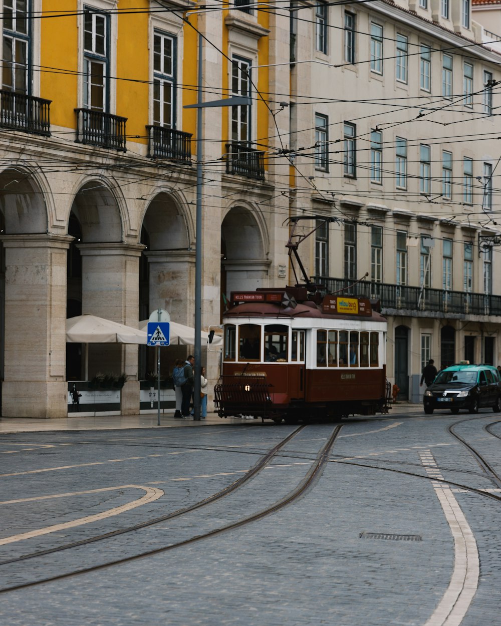 Eine Straßenbahn, die eine Straße neben hohen Gebäuden entlangfährt