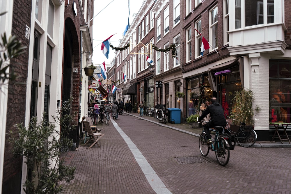 a man riding a bike down a street next to tall buildings