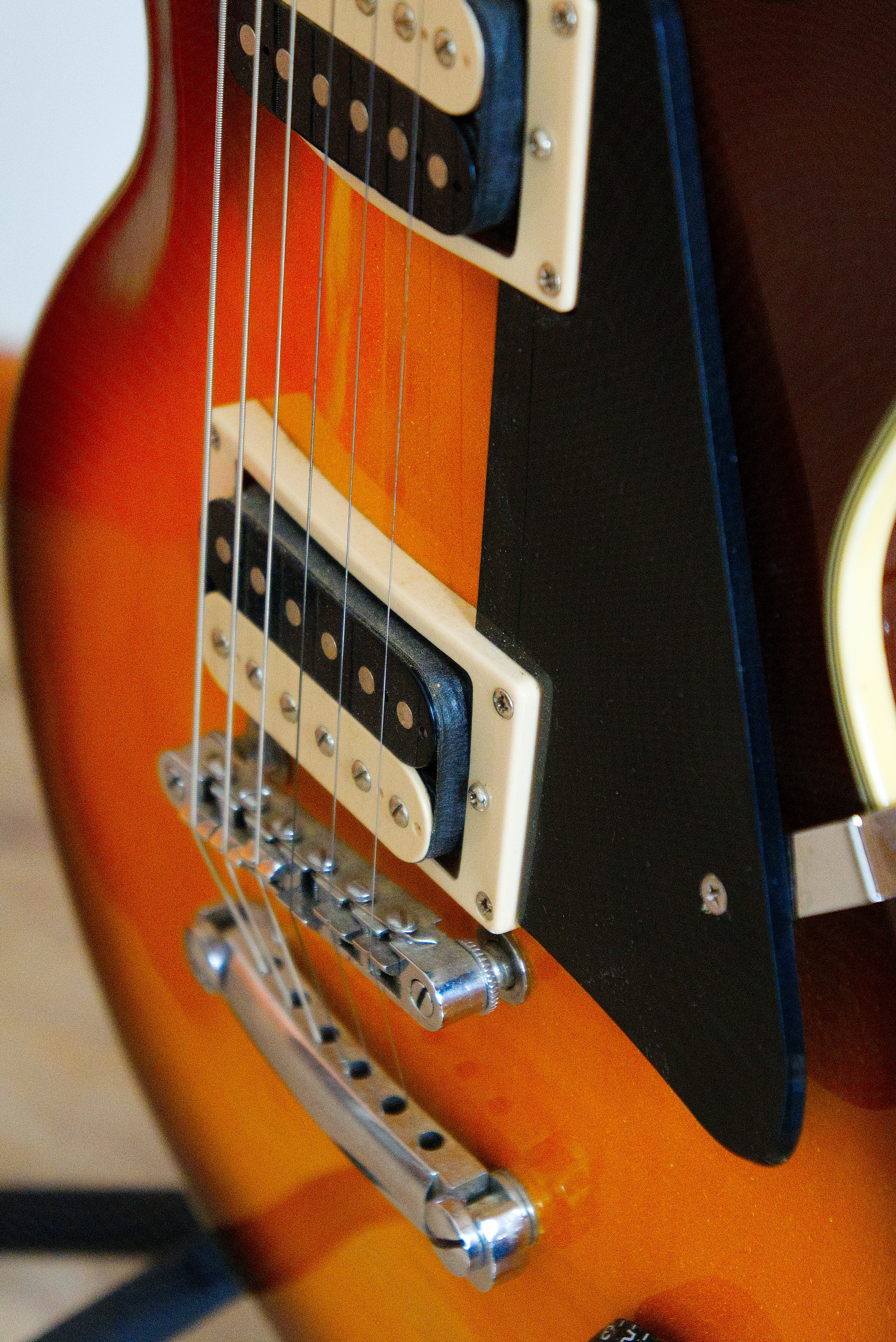 a close up of an electric guitar with a brown body