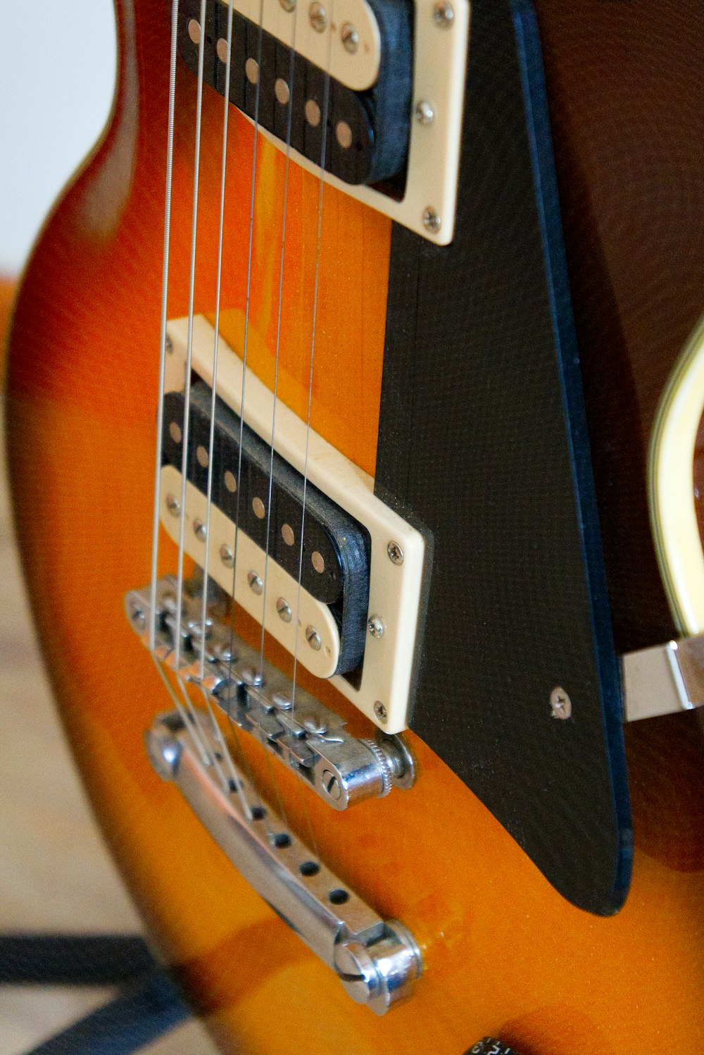 a close up of an electric guitar with a brown body
