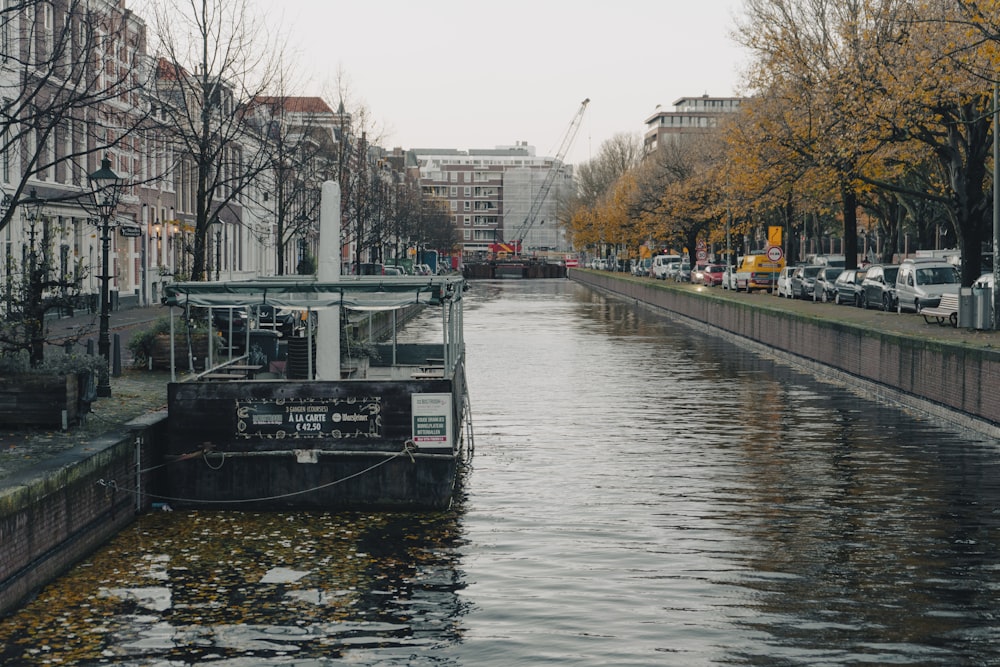 Un barco que viaja por un río junto a edificios altos