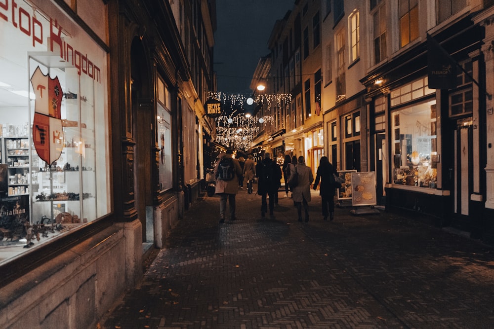 a group of people walking down a street at night