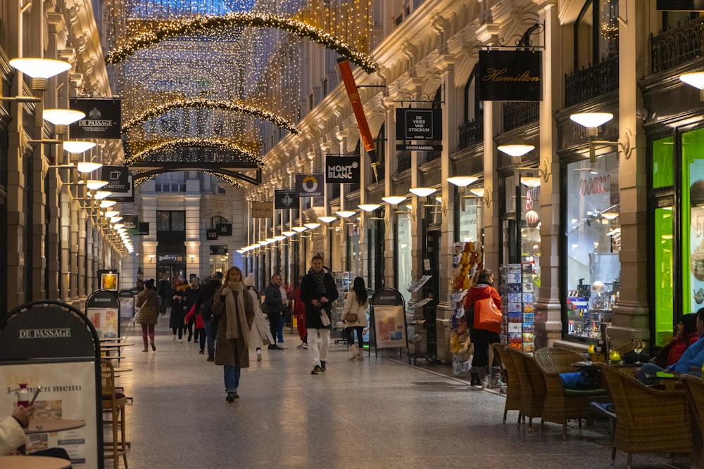 a group of people walking down a shopping mall