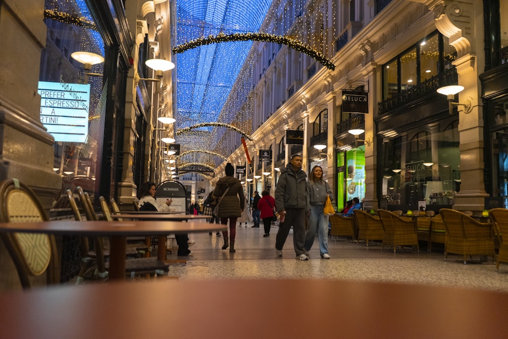 a group of people walking down a street next to tall buildings