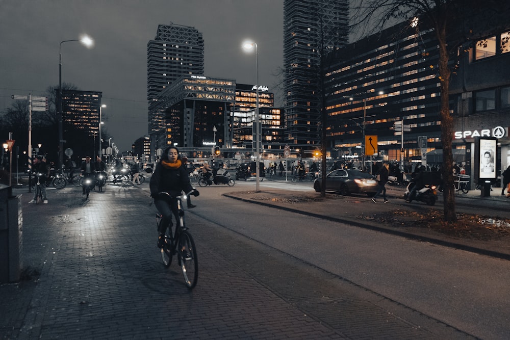 a man riding a bike down a street next to tall buildings