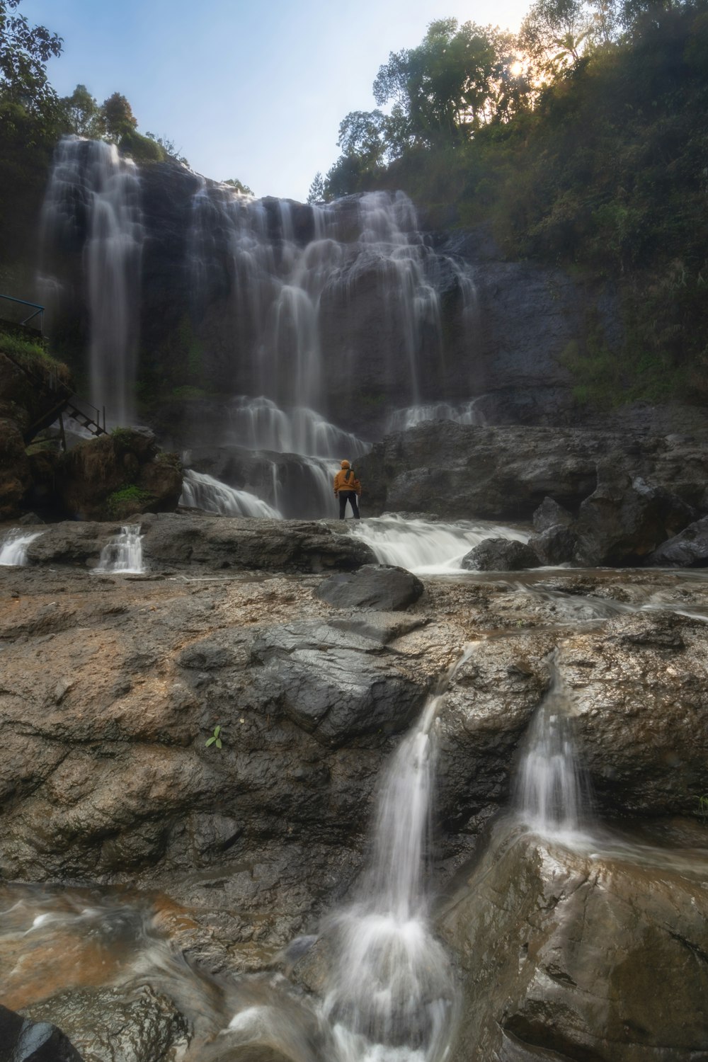 a man standing in front of a waterfall