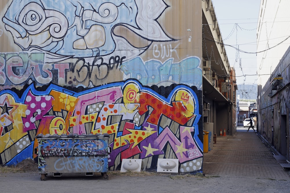 a wall covered in graffiti next to a building