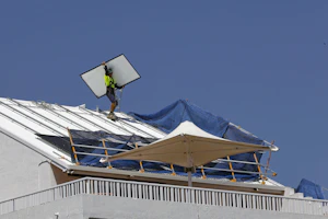 Man on a roof fixing a solar panel