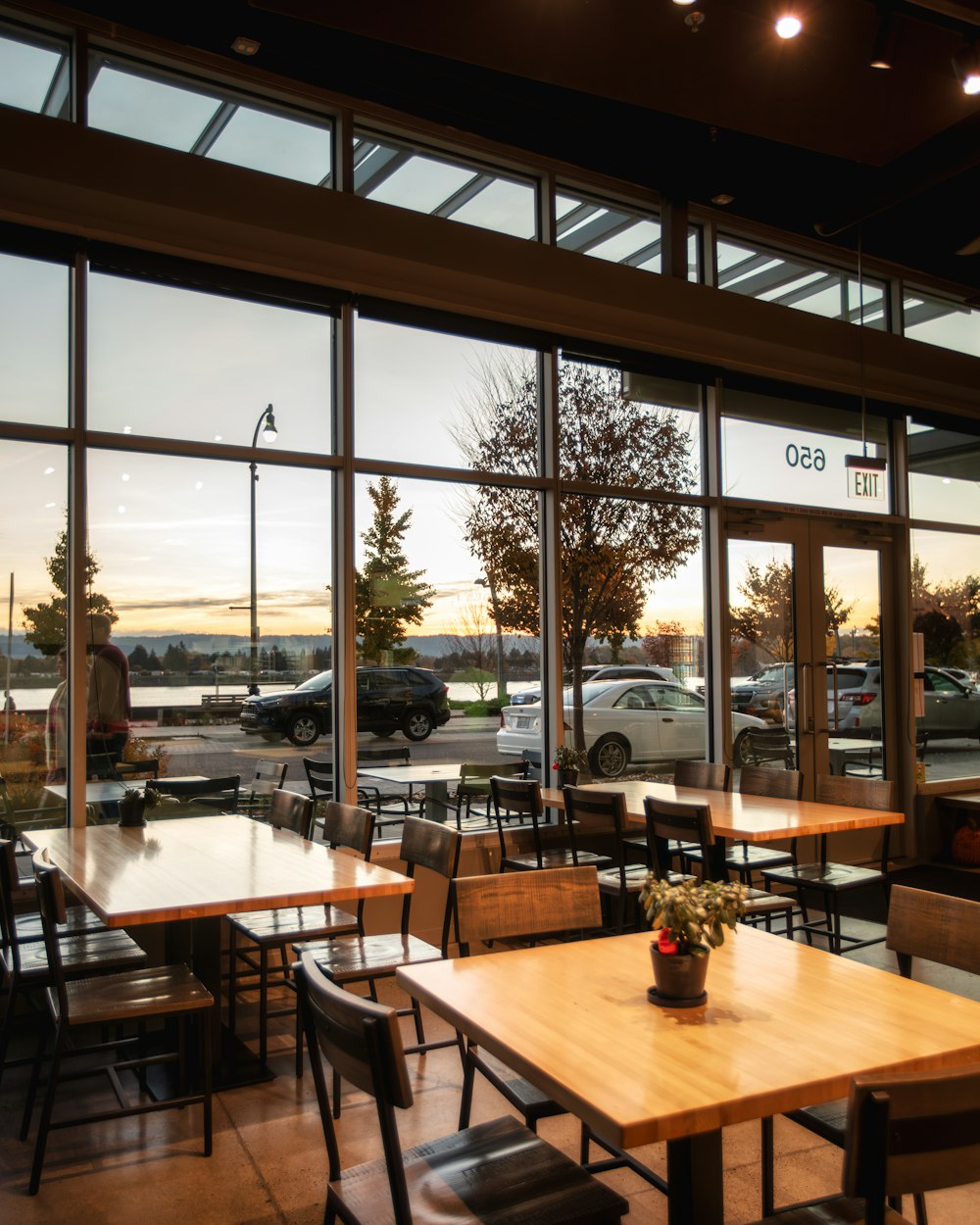 a restaurant with large windows and wooden tables