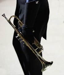 a man in a suit and tie holding a trumpet