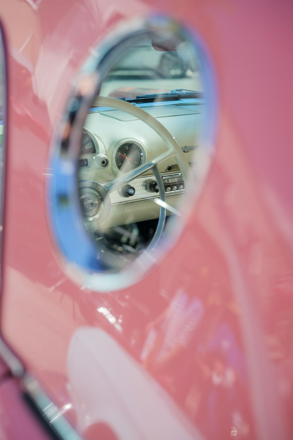 a pink car with a mirror on the side of it