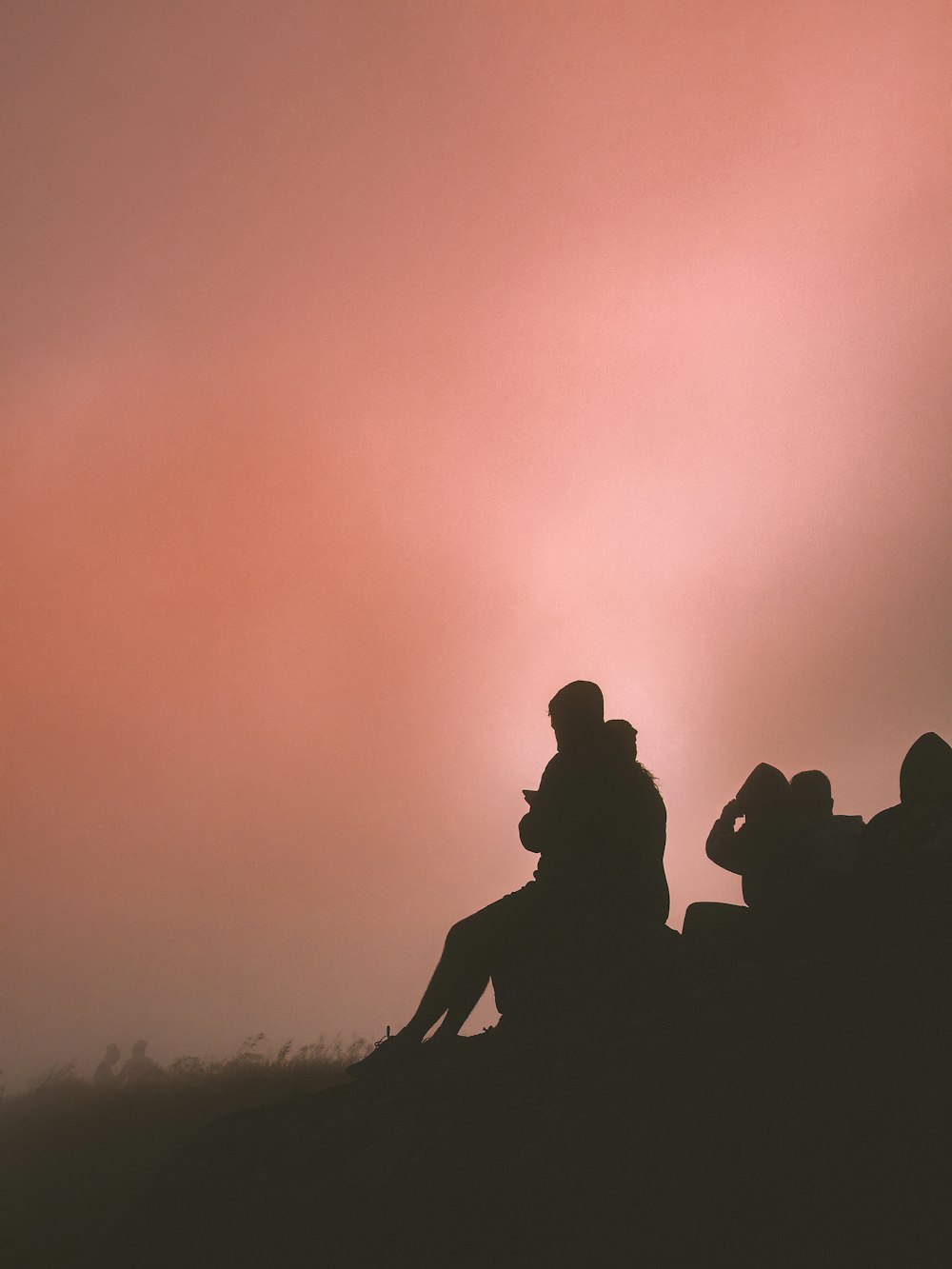 a group of people sitting on top of a hill