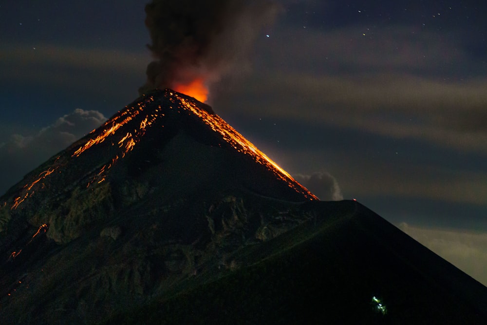 Ein Vulkan stößt Rauch aus, als er in den Nachthimmel ausbricht