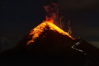 a volcano erupts lava as it erupts into the night sky