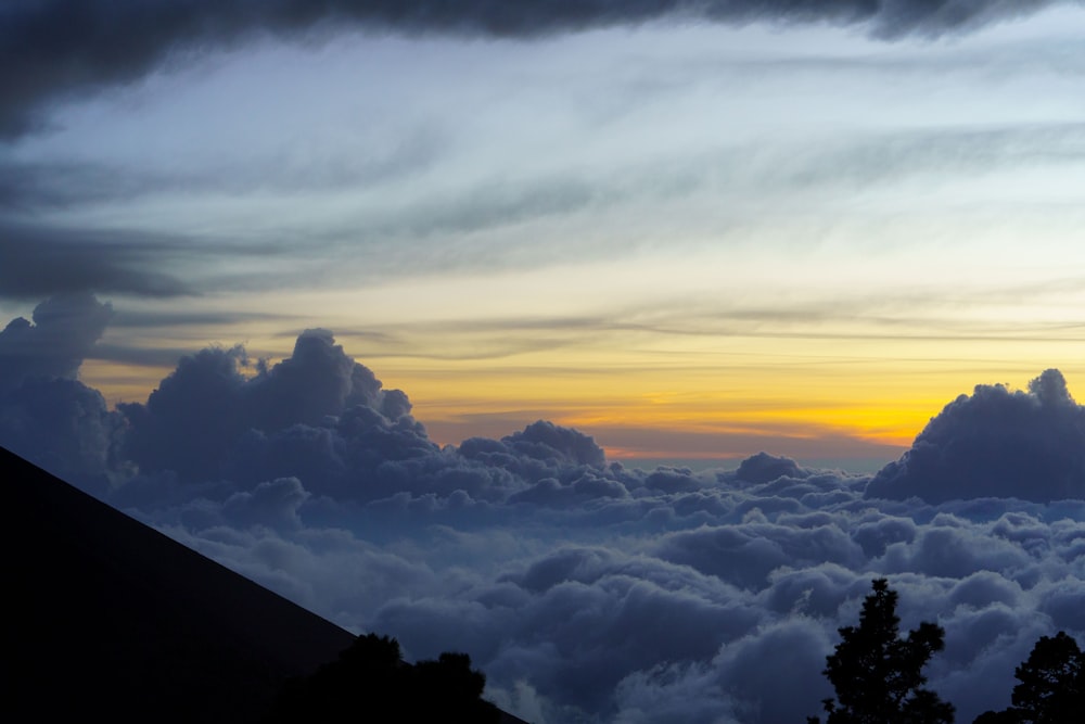 the sun is setting over the clouds in the sky