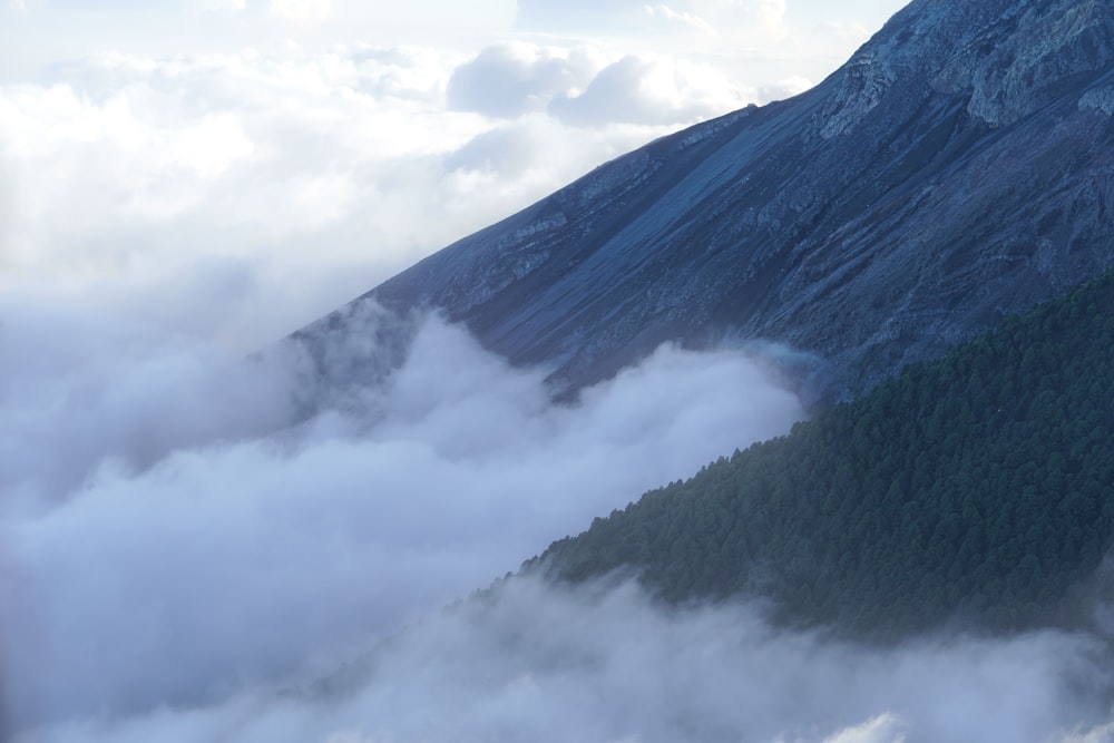 a mountain covered in clouds and trees