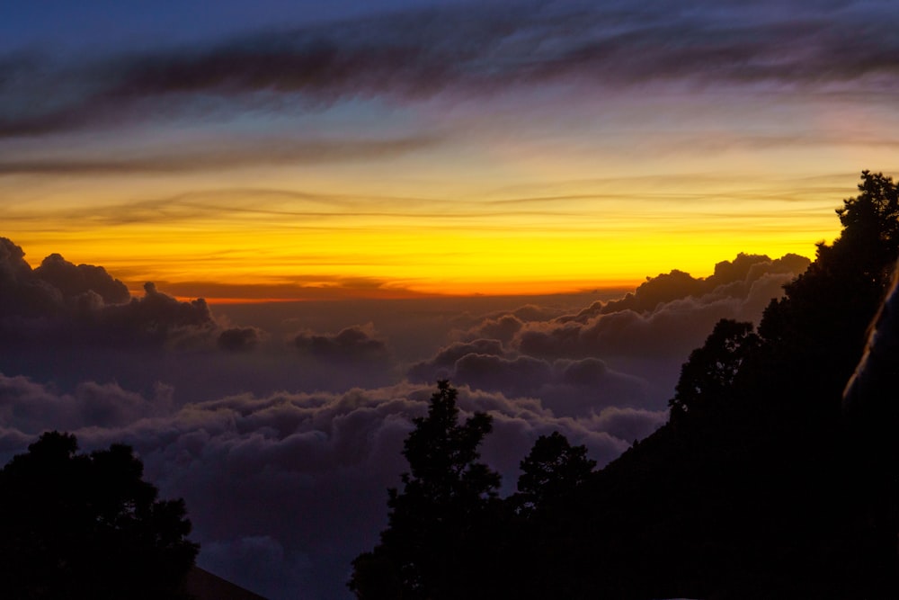 the sun is setting over the clouds in the sky