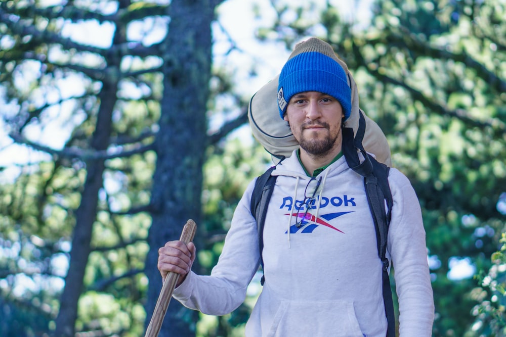 a man wearing a hat and holding a stick