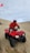 a man riding on the back of a red four wheeler