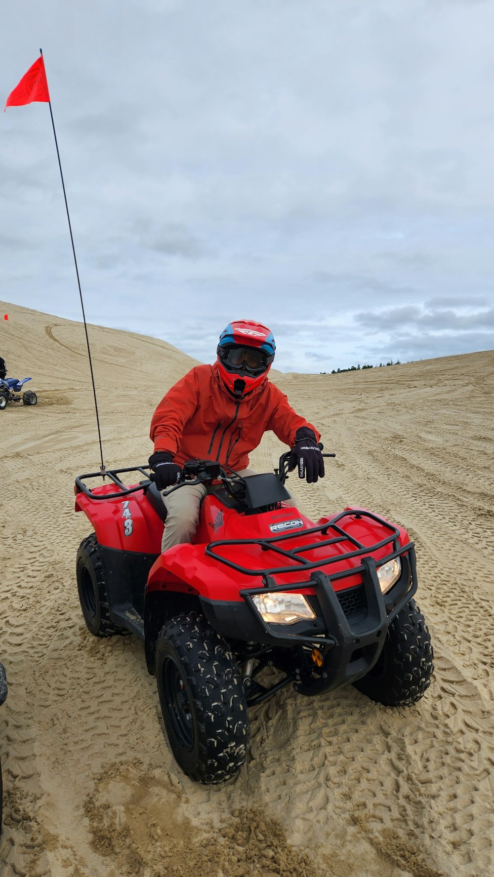 a man riding on the back of a red four wheeler