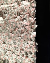 A large pile of printed paper tags, predominantly featuring printed text in black and red. Each tag includes a number and the word 'THE MET', suggesting a connection to a museum or exhibition entry system. The tags are scattered and overlapping each other, creating a sense of chaos and disorganization.