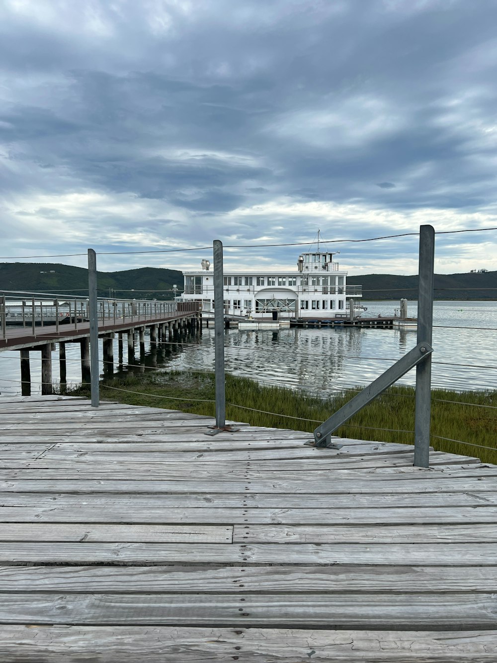 a wooden dock with a large white building in the background