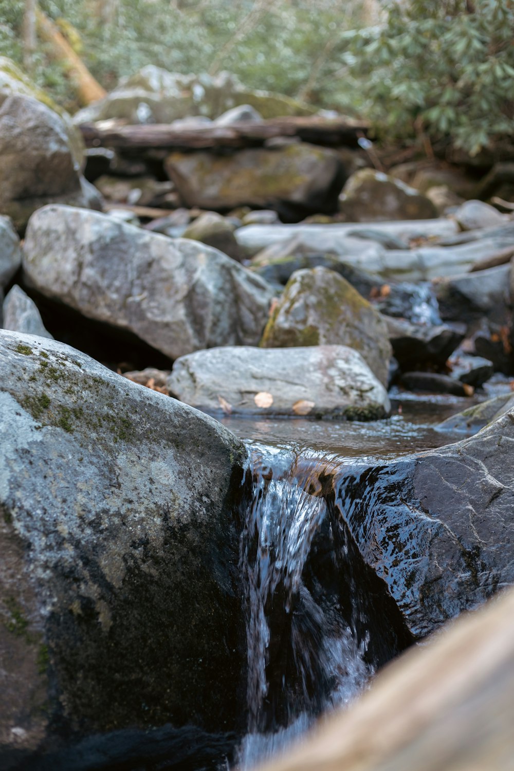 a stream of water running over rocks in a forest