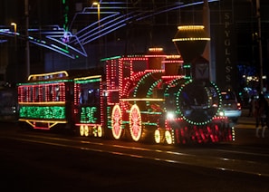 The Maple Choo Choo illuminated with LED lights at a nighttime event.