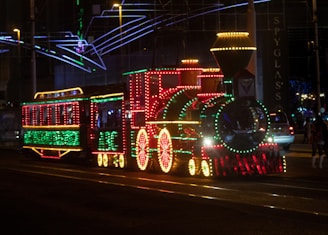 The Maple Choo Choo illuminated with LED lights at a nighttime event.