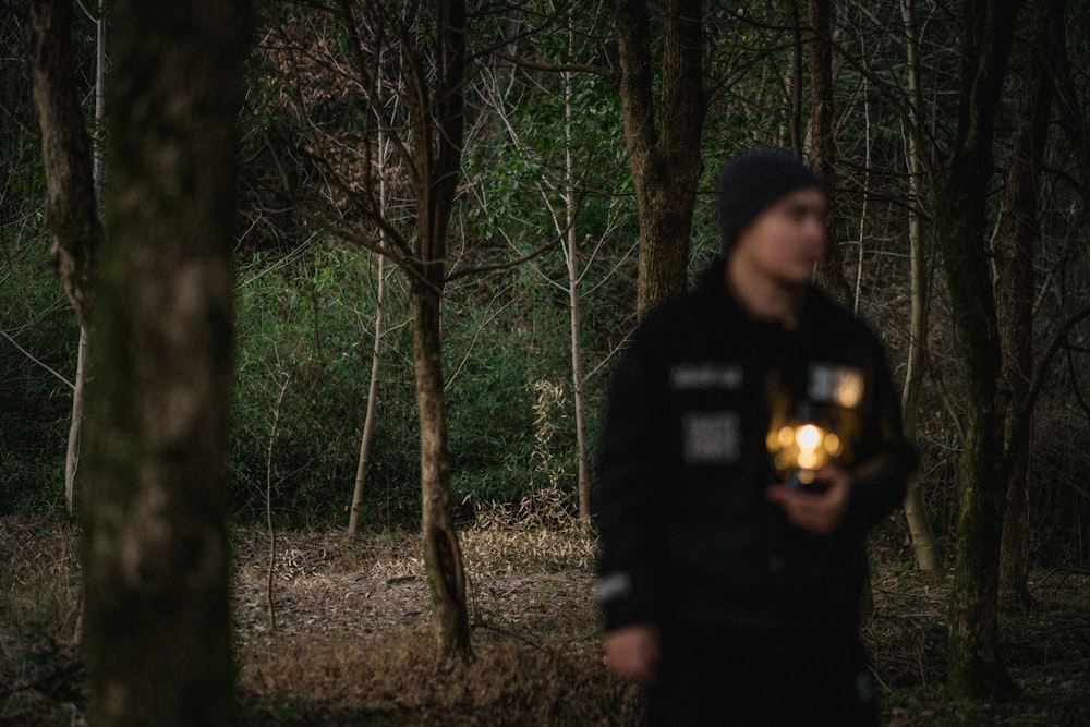 a man standing in the woods holding a flashlight