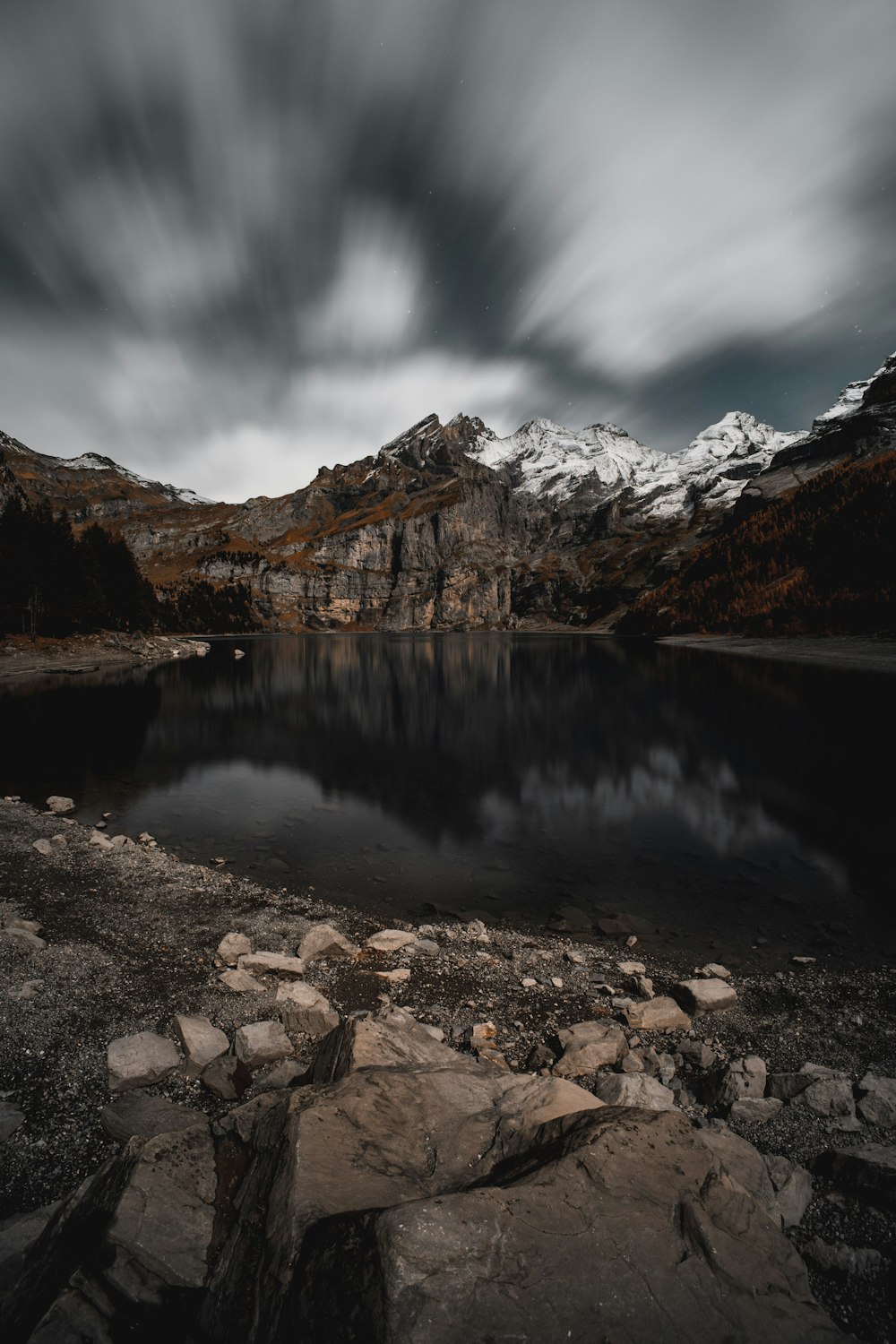 a mountain lake surrounded by rocks under a cloudy sky