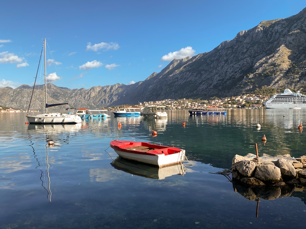 a red boat floating on top of a body of water