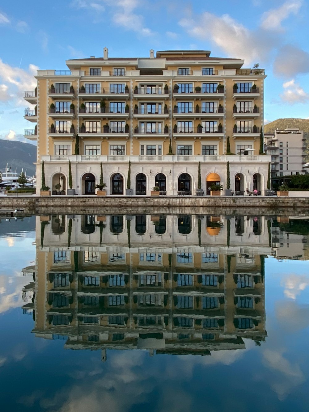 un grande edificio seduto accanto a uno specchio d'acqua