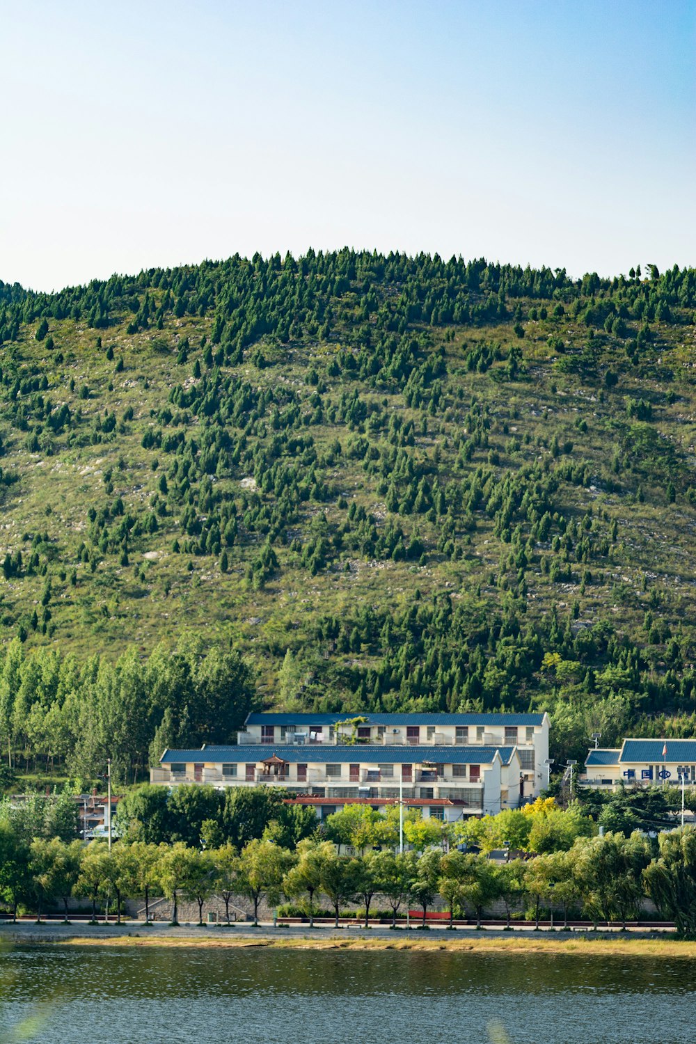 a large white building sitting on top of a lush green hillside