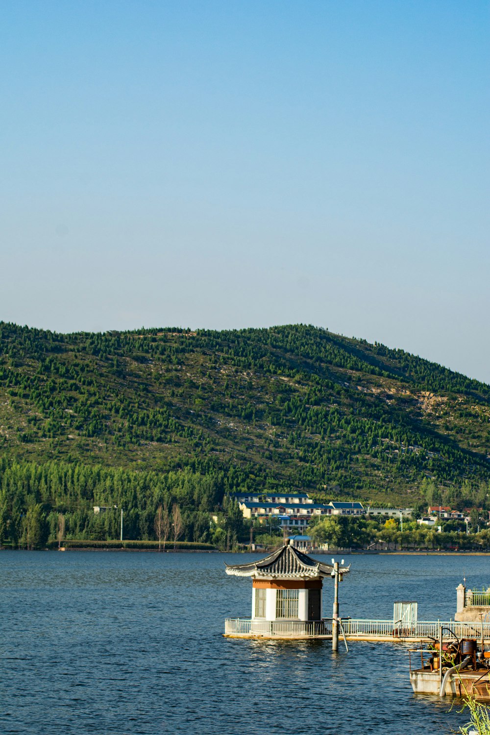 a lake with a house on it and a mountain in the background