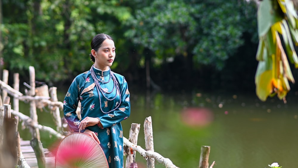 a woman standing on a bridge holding an umbrella